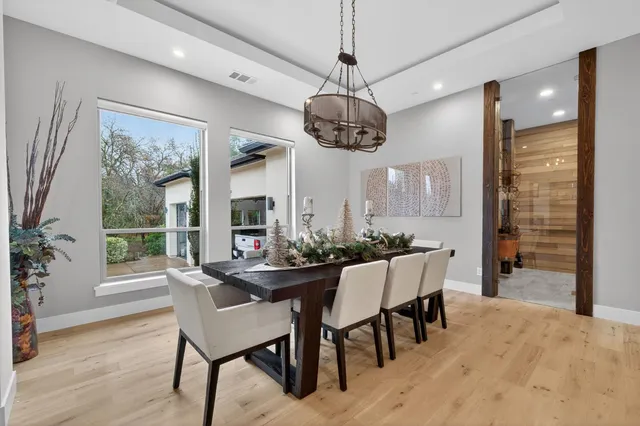 a dining room with wooden floor and a chandelier
