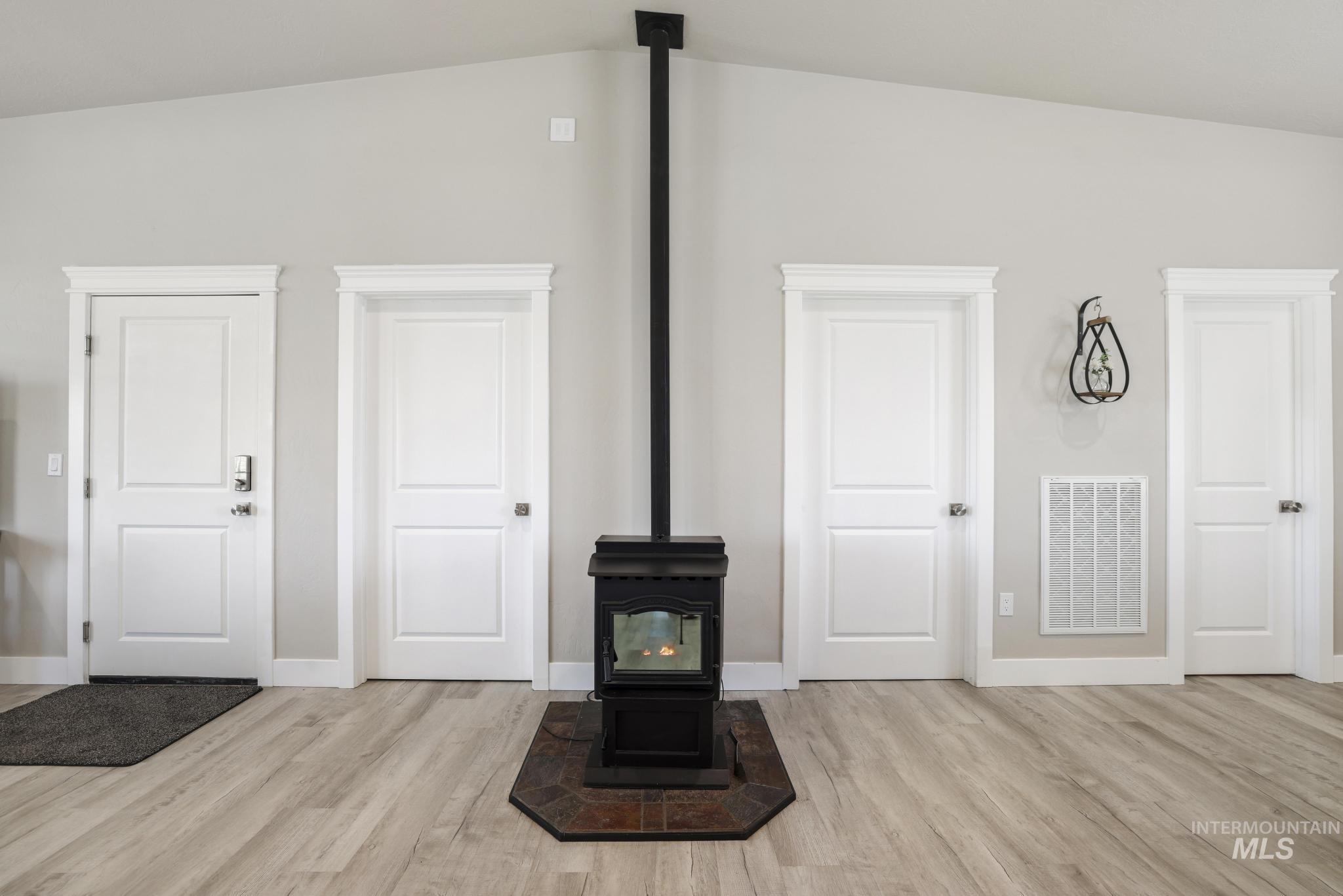 758 Cedar Crk Road Rogerson, ID 83302 - Photo 12 of 50 Central freestanding fireplace with a dark metal finish and tile hearth