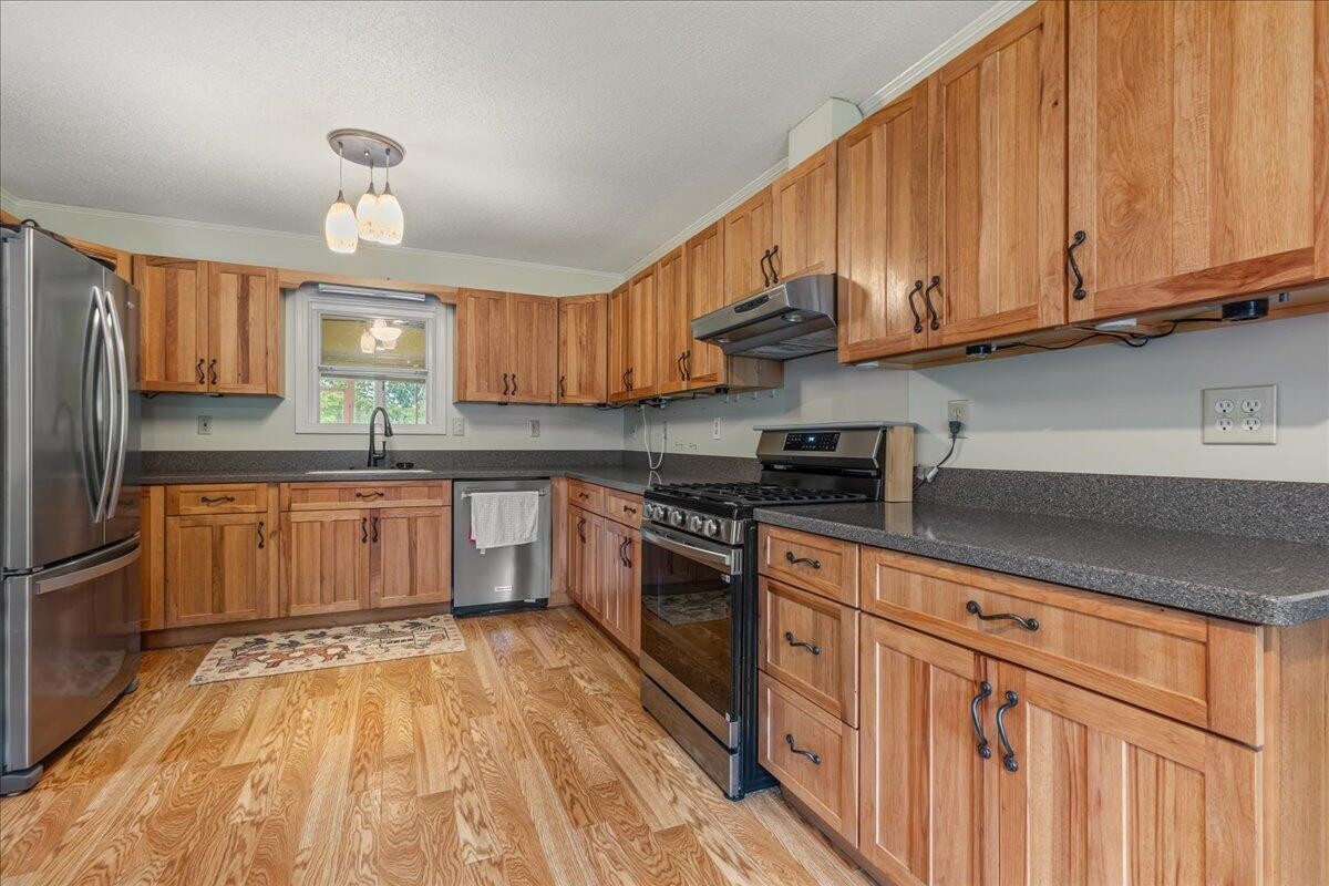2522 Cindy Street Athens, TN 37303 - Photo 14 of 36 a kitchen with stainless steel appliances granite countertop a stove a sink dishwasher and a refrigerator with wooden floor