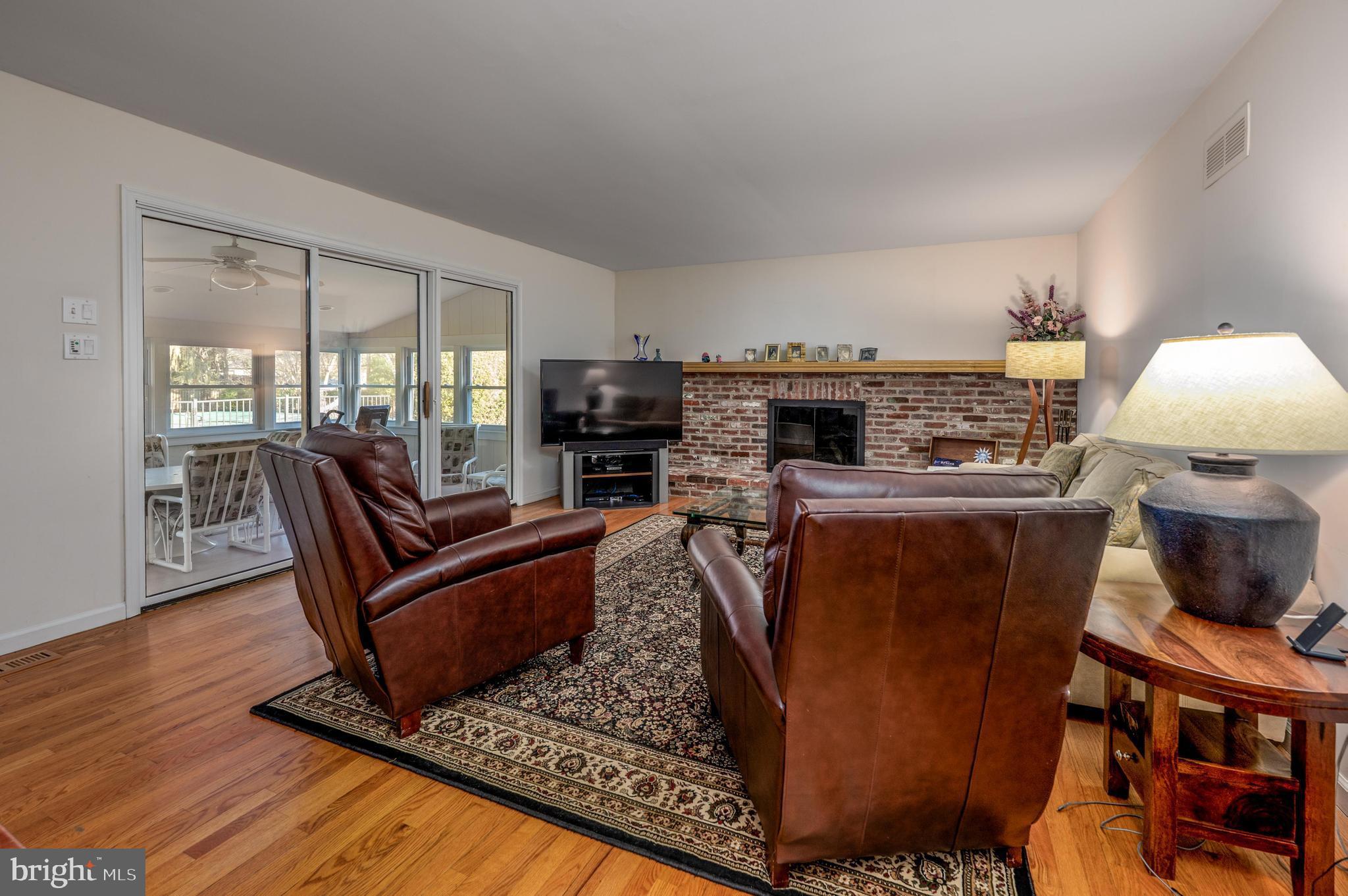 596 Sentinel Road Moorestown, NJ 08057 - Photo 11 of 31 a living room with furniture a flat screen tv and a floor to ceiling window