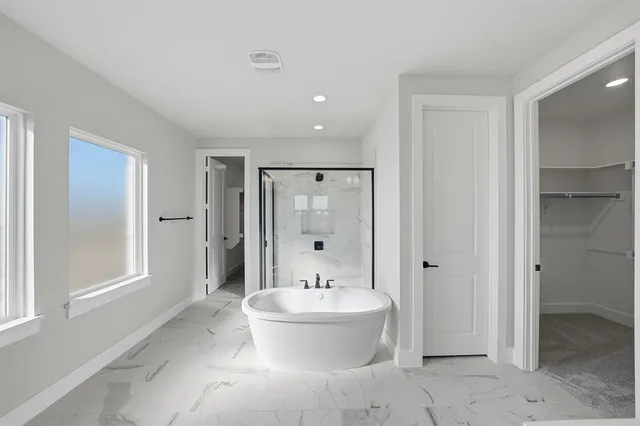 a bathroom with a bathtub shower sink and mirror