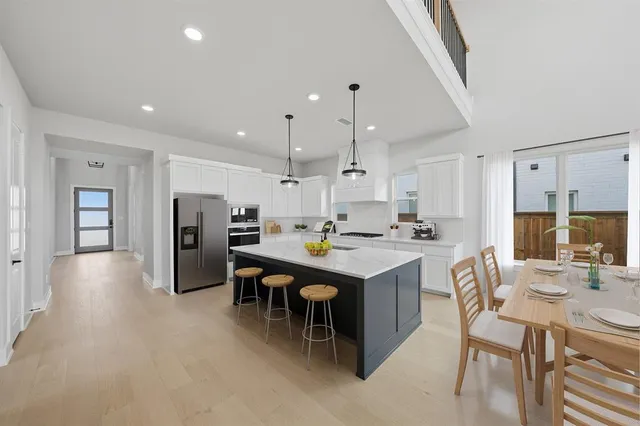 a kitchen with refrigerator and chairs