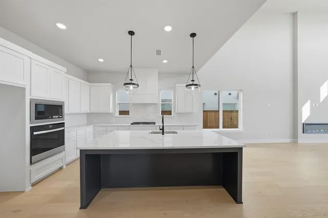 a large kitchen with a large counter top appliances and cabinets