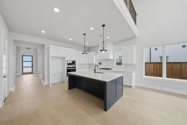 a large kitchen with kitchen island a sink stainless steel appliances and cabinets
