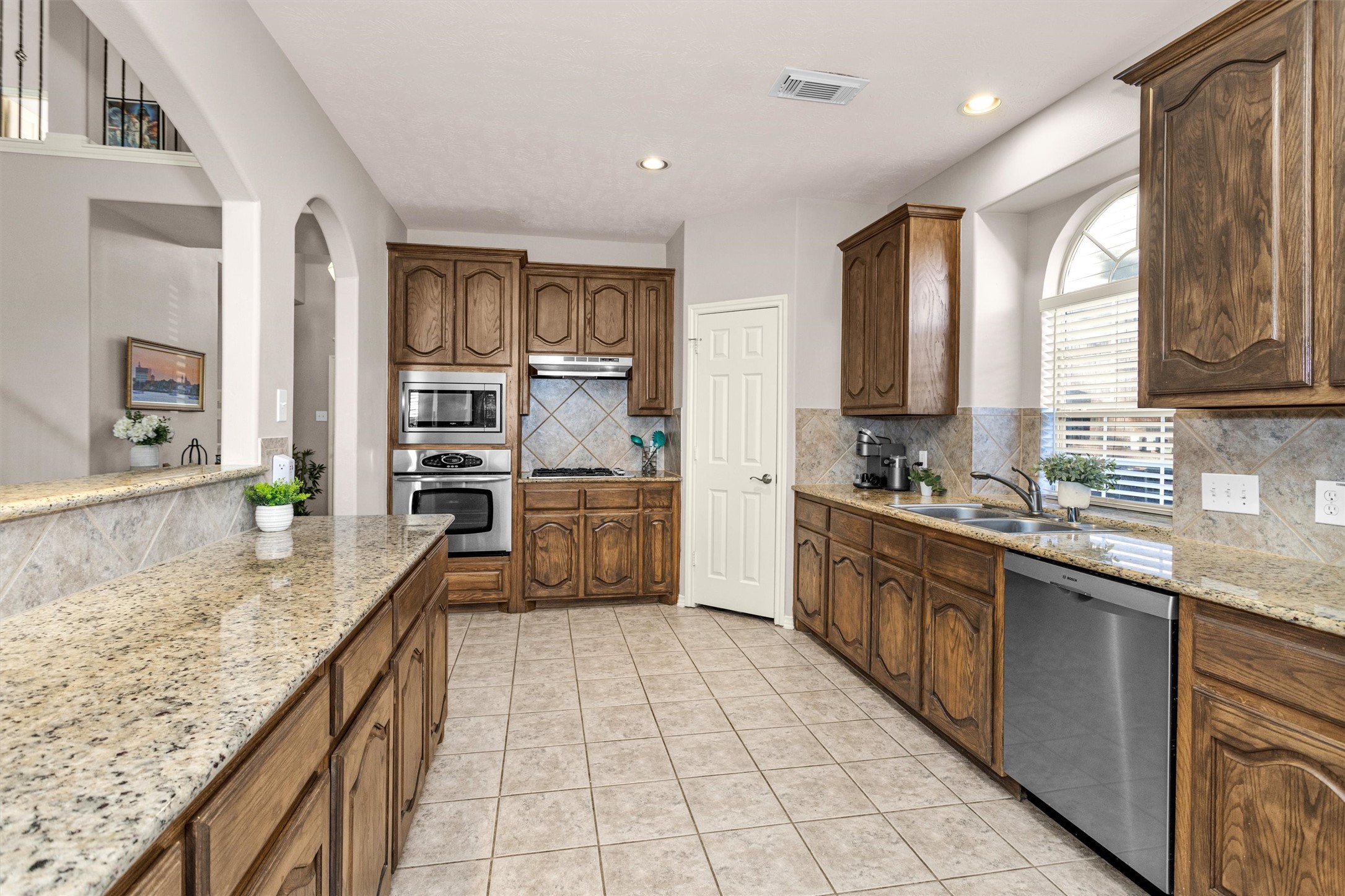 30110 Legends Ridge Drive Spring, TX 77386 - Photo 4 of 49 a kitchen with stainless steel appliances granite countertop a sink counter space cabinets and a large window