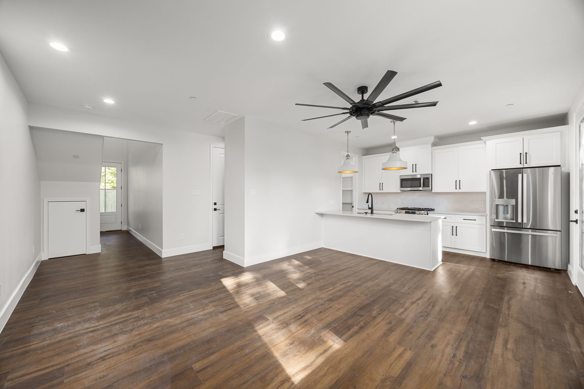 a kitchen with stainless steel appliances sink cabinets and wooden floor