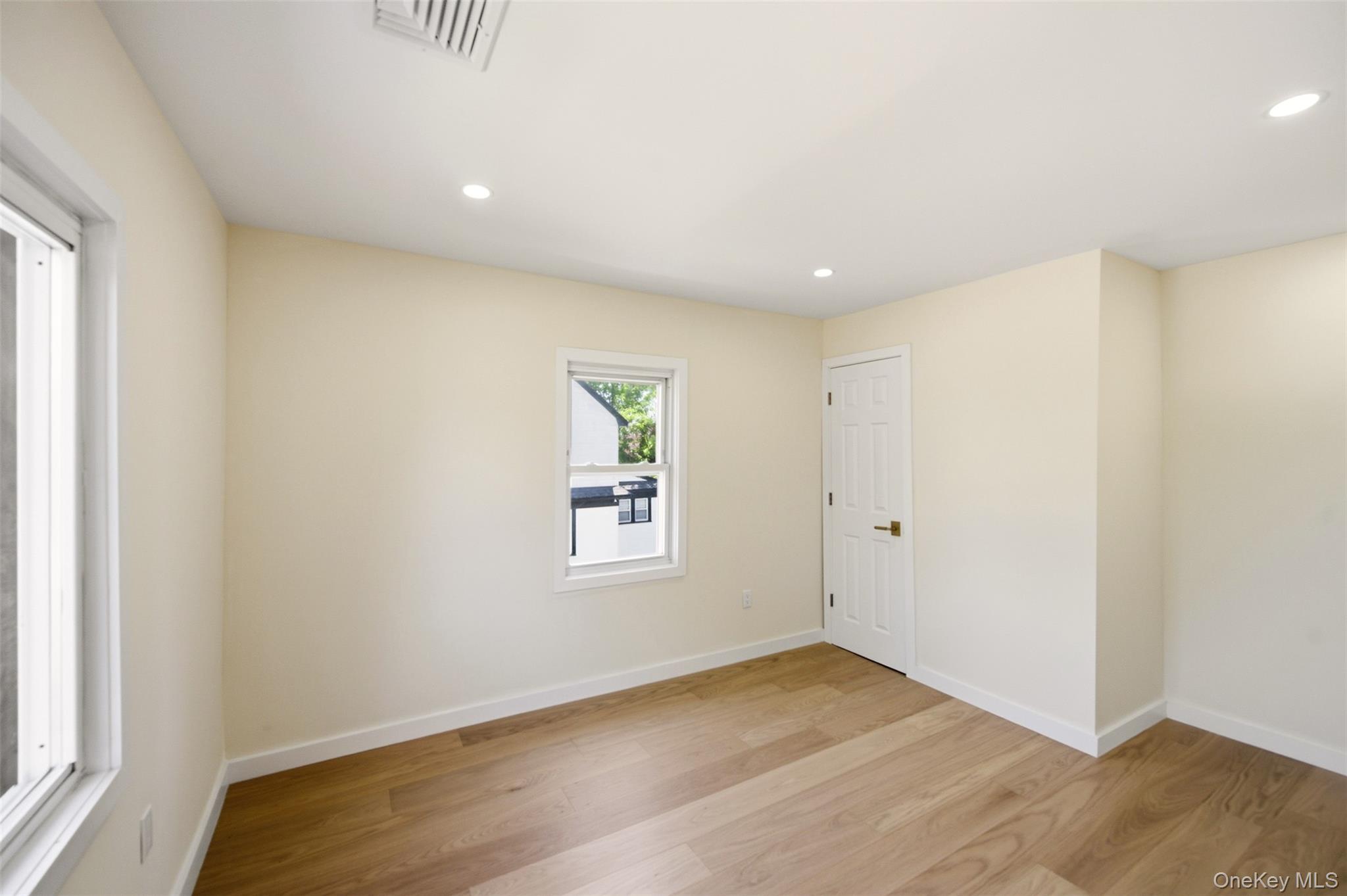 135 Whaley Street Freeport, NY 11520 - Photo 26 of 38 an empty room with wooden floor and windows