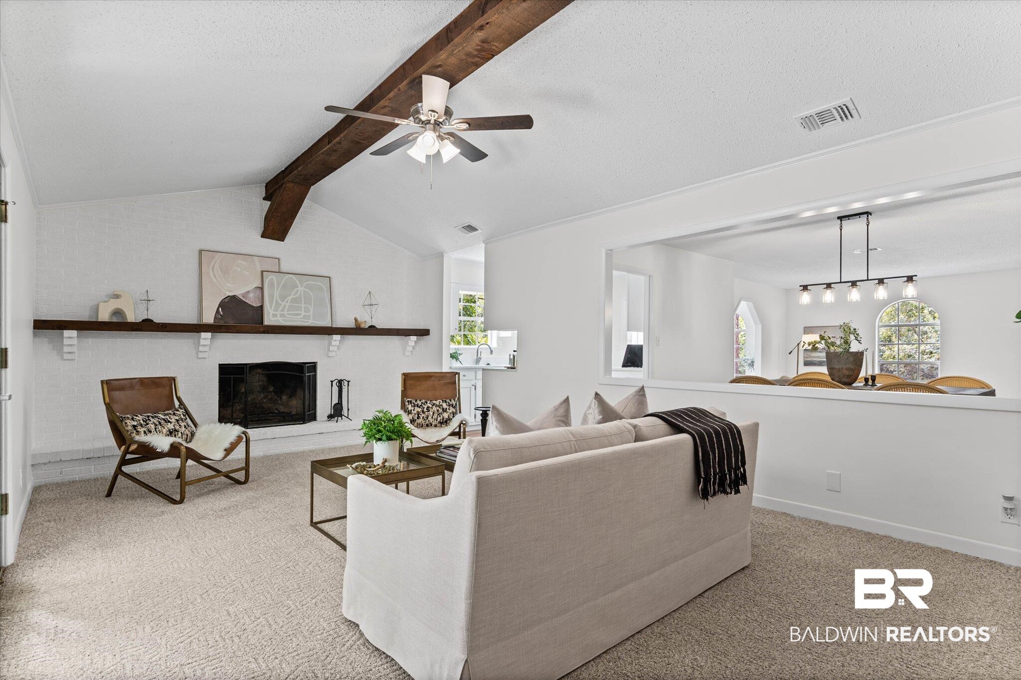 9 Bull Run Road Spanish Fort, AL 36527 - Photo 11 of 23 Vaulted ceiling living area featuring a fireplace with hearth, exposed wood beam, ceiling fan, and a pass-through opening to an additional room