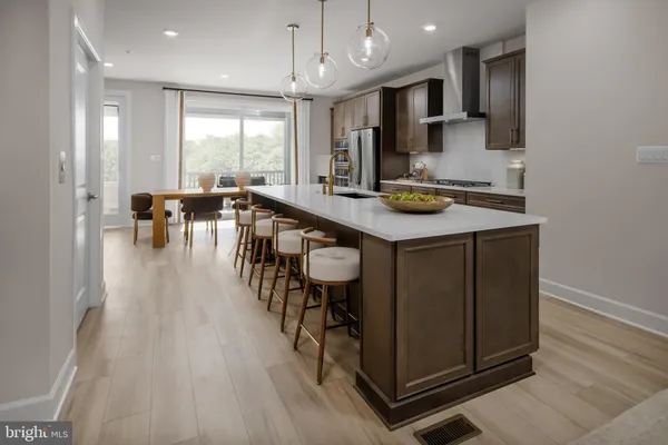 a kitchen with stainless steel appliances granite countertop table chairs sink and cabinets