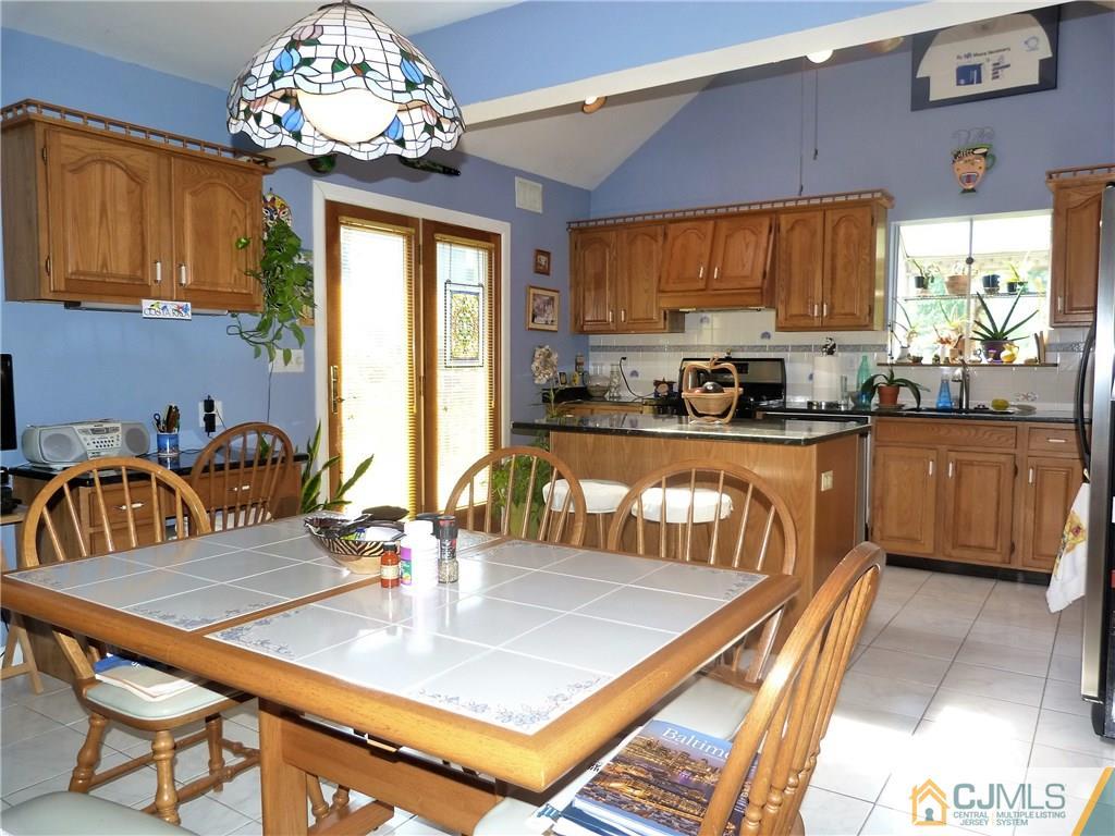 45 South Pennington Road New Brunswick, NJ 08901 - Photo 3 of 21 a kitchen with granite countertop a stove a sink a dining table and chairs