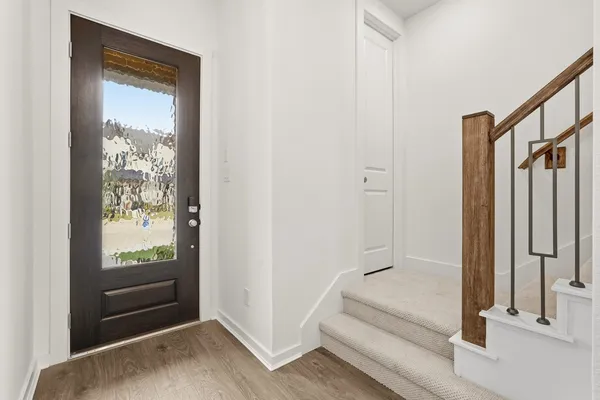 an empty room with wooden floor cabinet and windows