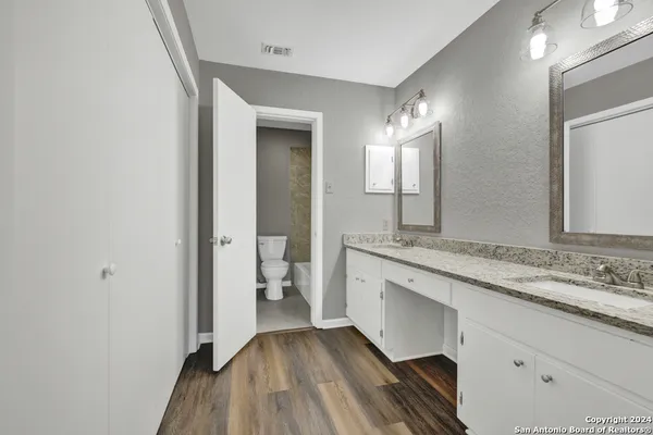 a spacious bathroom with a granite countertop sink and a mirror