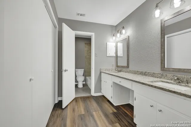 a spacious bathroom with a granite countertop sink and a mirror