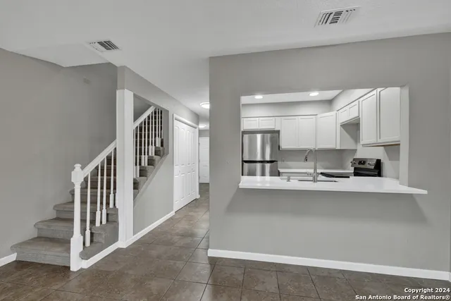 a kitchen with stainless steel appliances a sink and cabinets