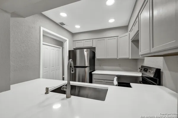 a kitchen with stainless steel appliances a refrigerator and a stove top oven