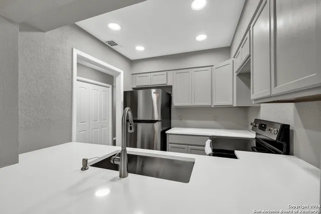 a kitchen with stainless steel appliances a refrigerator and a stove top oven