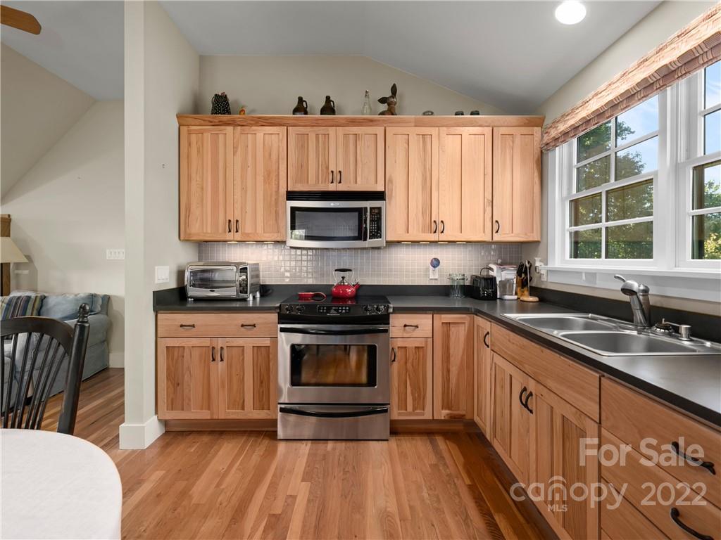 116 Stone Brook Trail Black Mountain, NC 28711 - Photo 13 of 48 a kitchen with stainless steel appliances granite countertop a stove a sink dishwasher and a microwave oven with wooden floor
