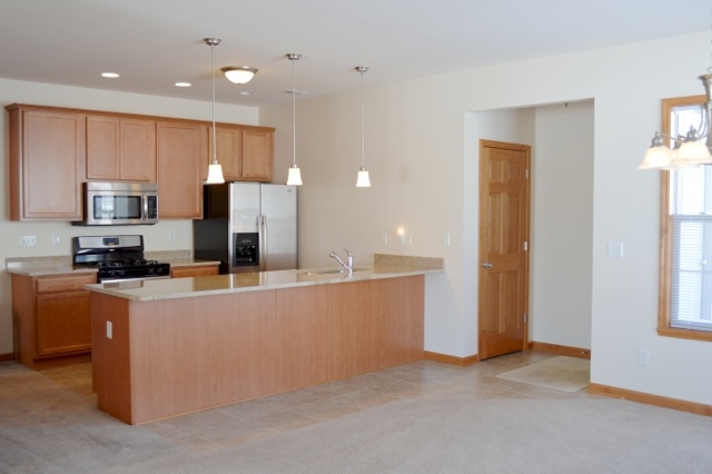 10187 Marblewing Road, Unit 2 Roscoe, IL 61073 - Photo 5 of 12 a kitchen with stainless steel appliances a refrigerator a sink a stove top oven a window and white cabinets