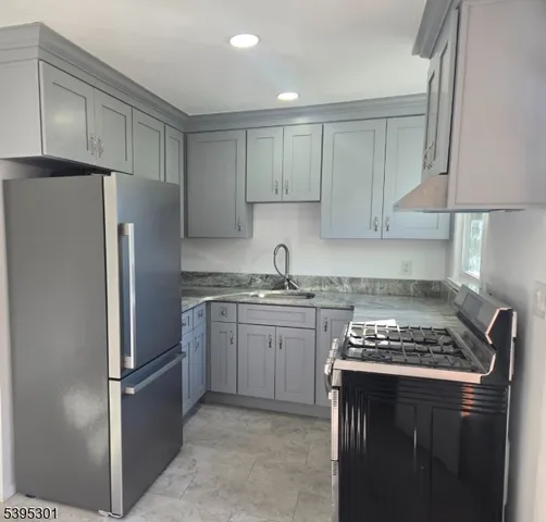 a kitchen with stainless steel appliances granite countertop a refrigerator stove and sink