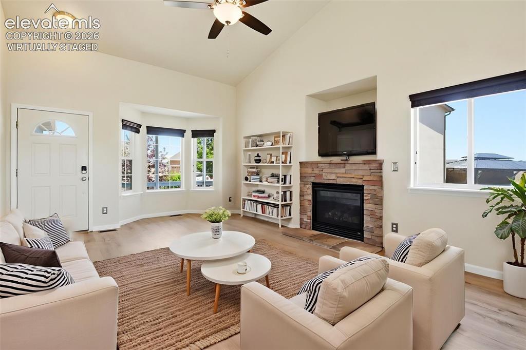 7806 Dutch Loop Colorado Springs, CO 80925 - Photo 3 of 41 a living room with furniture a flat screen tv and a fireplace