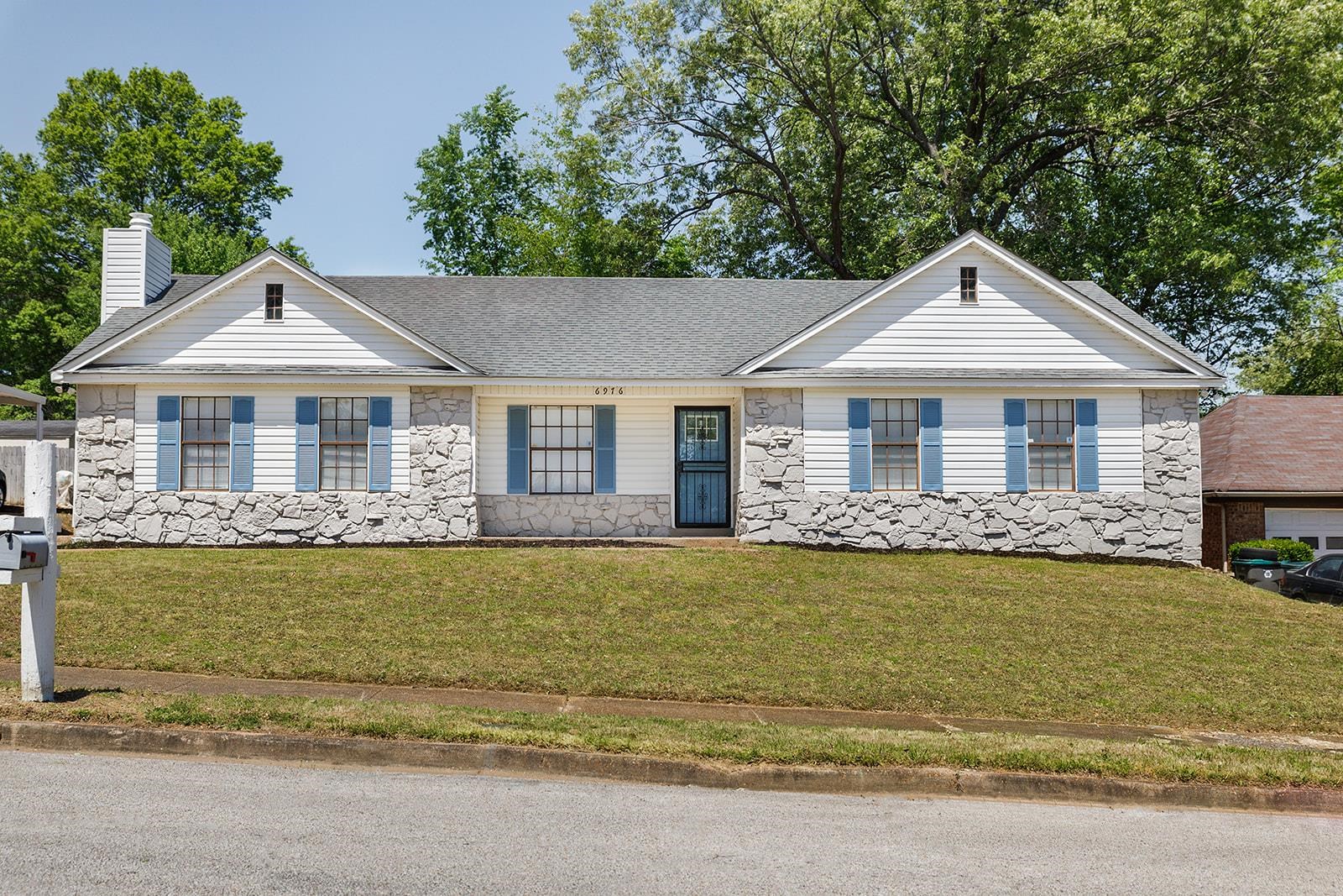6976 Rockingham Road Memphis, TN 38125 - Photo 1 of 24 a front view of a house with a garden