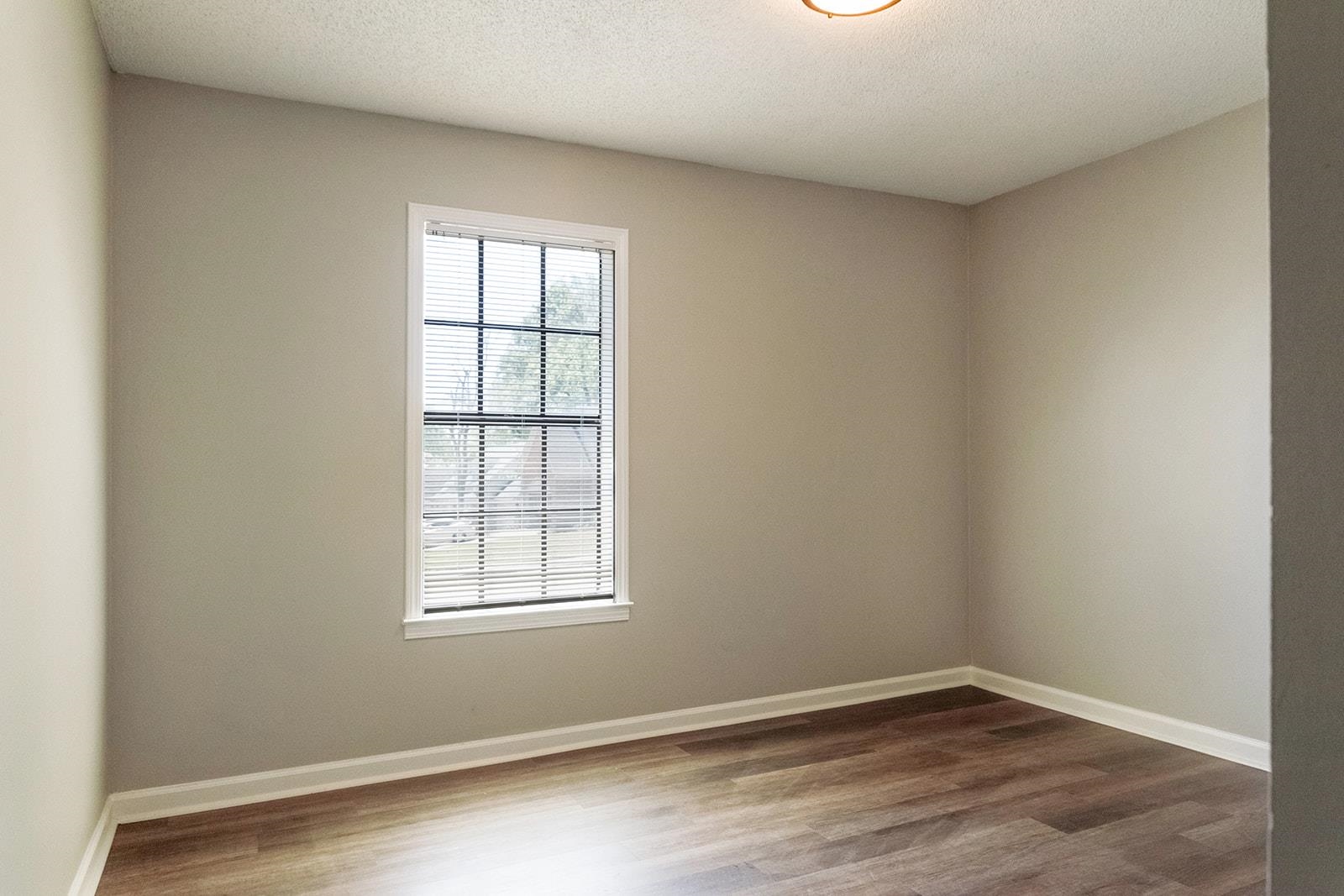 6976 Rockingham Road Memphis, TN 38125 - Photo 13 of 24 an empty room with wooden floor and windows