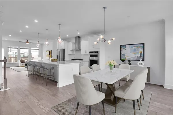 a view of a dining room and livingroom with furniture wooden floor a rug a chandelier