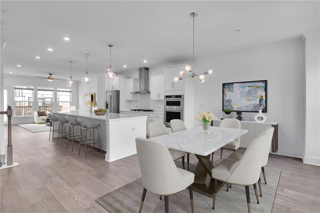 a view of a dining room and livingroom with furniture wooden floor a rug a chandelier