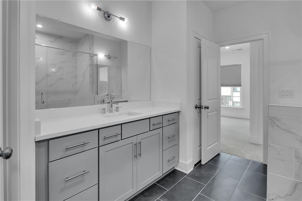 545 Whitlox Road Northwest Atlanta, GA 30309 - Photo 24 of 65 a bathroom with a shower sink and mirror