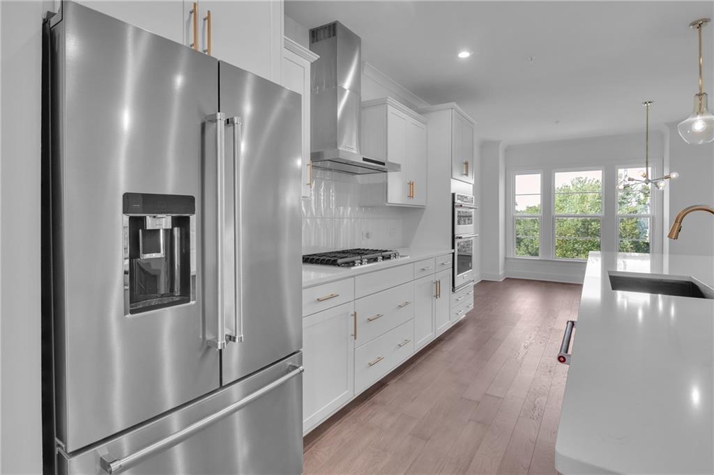 545 Whitlox Road Northwest Atlanta, GA 30309 - Photo 9 of 65 a kitchen with stainless steel appliances a refrigerator and a view of living room