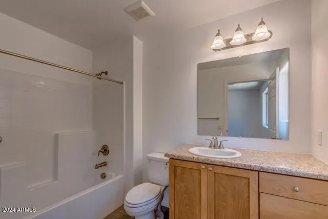 a bathroom with a granite countertop sink a toilet and shower