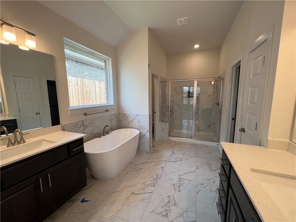 982 Wild Pecan Loop Buda, TX 78610 - Photo 11 of 16 Relax in Spa like primary bathroom with dual vanities, free standing tub and walk in shower