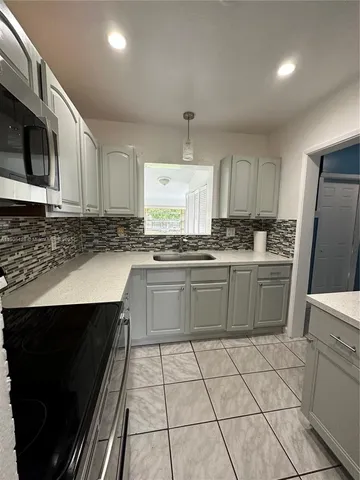 a kitchen with a sink a stove a microwave and cabinets