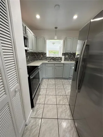 a kitchen with stainless steel appliances a refrigerator sink and stove