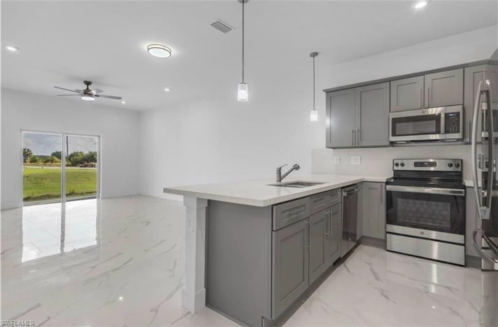 402 Grant Boulevard Lehigh Acres, FL 33974 - Photo 2 of 9 a kitchen with a sink and stainless steel appliances