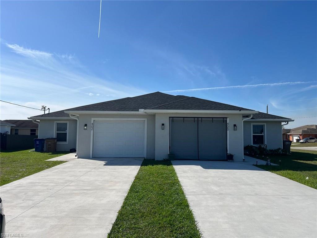 402 Grant Boulevard Lehigh Acres, FL 33974 - Photo 9 of 9 a front view of a house with a yard and garage