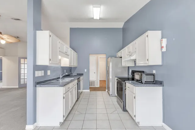 a kitchen with stainless steel appliances a sink stove and cabinets