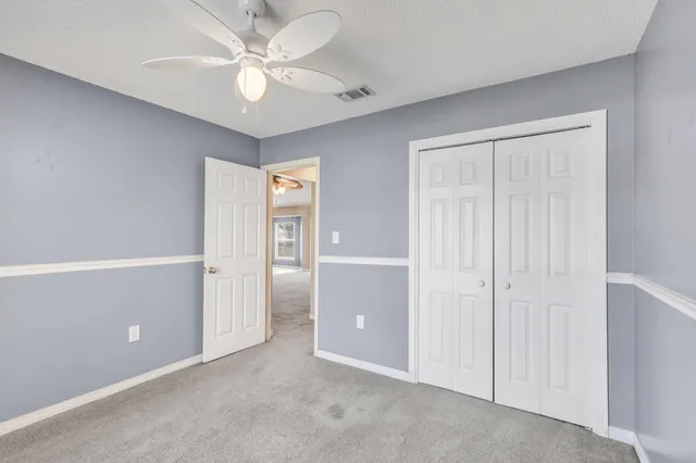 an empty room with closet and windows