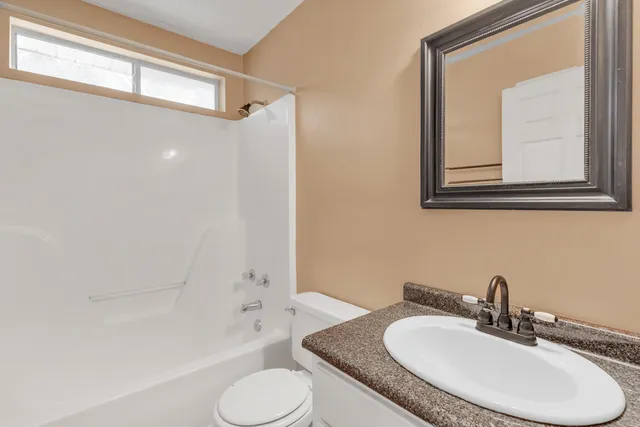 a bathroom with a granite countertop sink toilet and shower