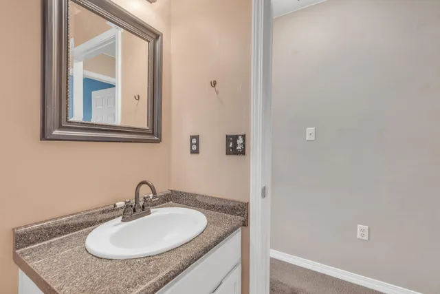 a bathroom with a granite countertop sink and a mirror