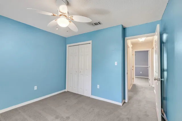an empty room with a bathroom and a ceiling fan
