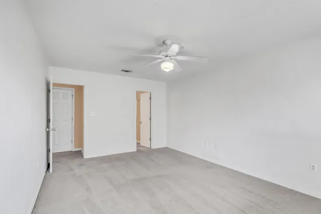 an empty room with fan and a ceiling fan