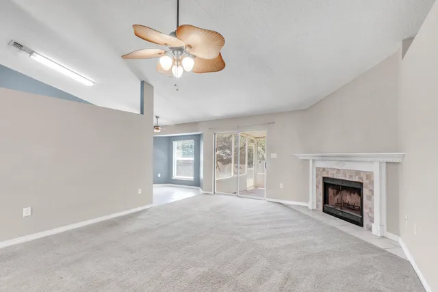 a view of an empty room with a fireplace and a window