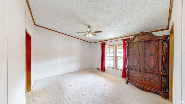 718 South State Street Genola, UT 84655 - Photo 15 of 19 Carpeted room featuring multiple windows, a ceiling fan with integrated lighting, and white wall panels with wood trim