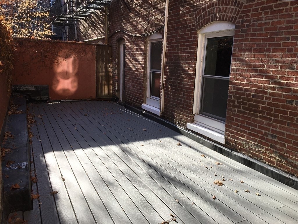 a view of backyard with wooden floor and a potted plant