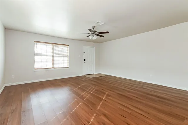 wooden floor in an empty room with a window