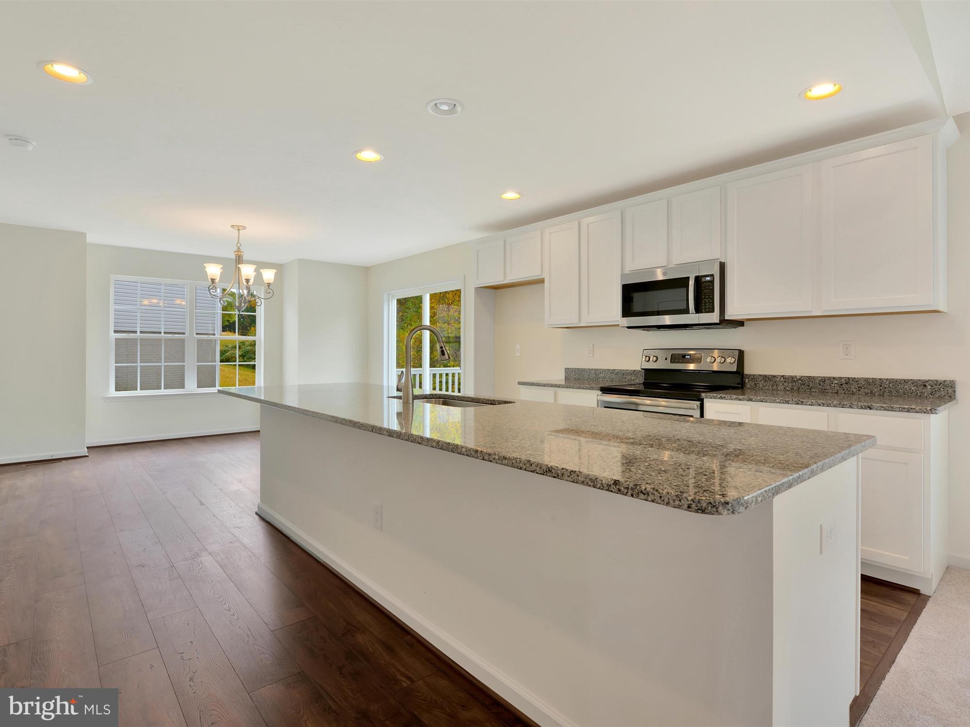 47 Huntmaster Drive Hanover, PA 17331 - Photo 8 of 22 a kitchen with stainless steel appliances granite countertop a sink a stove a microwave a center island and a window