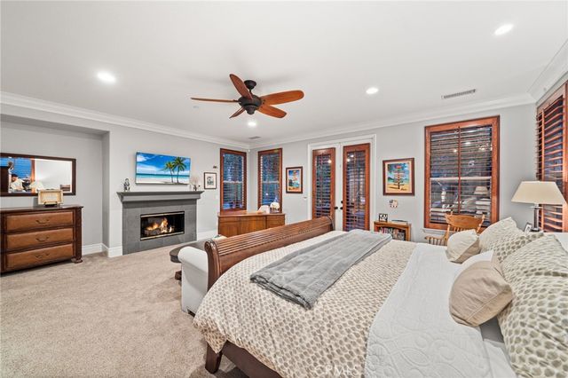 a spacious bedroom with a large bed a flat screen tv and a fireplace