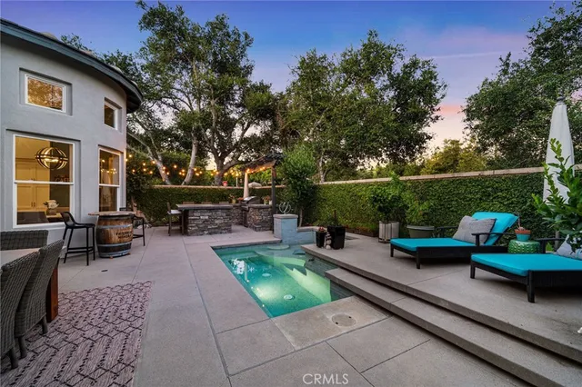 a view of a patio with couches table and chairs with potted plants and a table