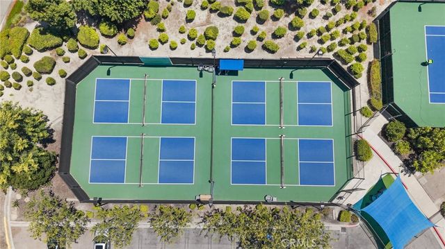 an aerial view of residential houses with outdoor space and trees